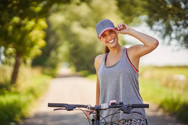 Mujer joven feliz disfrutando de un paseo en bicicleta en el campo