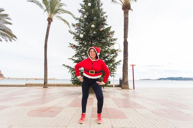 Mujer joven feliz divirtiéndose en traje de Navidad