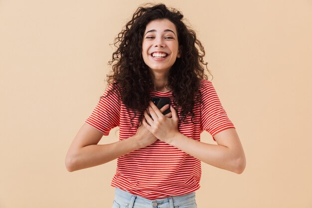 Mujer joven feliz emocionada emocional mediante teléfono móvil.