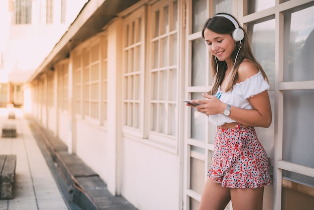 Foto mujer joven feliz escuchando música en el teléfono móvil