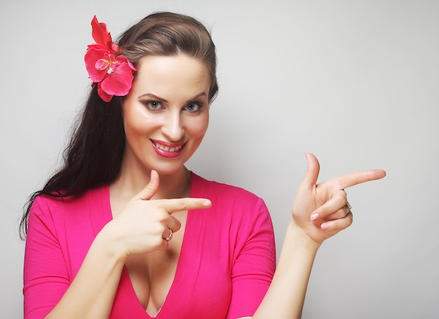 Mujer joven feliz con flor rosa en el pelo