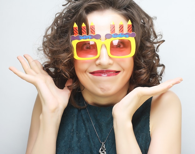 Mujer joven feliz con grandes gafas de sol naranjas, listo para la fiesta