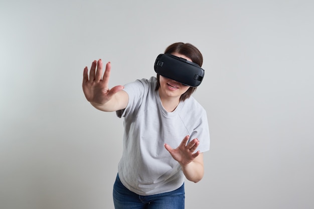 Mujer joven feliz jugando con gafas VR interior, concepto de realidad virtual con mujer joven divirtiéndose con gafas de auriculares, con espacio de copia