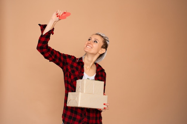 Mujer joven feliz mirando a San Valentín corazón rojo, regalo para el día de San Valentín