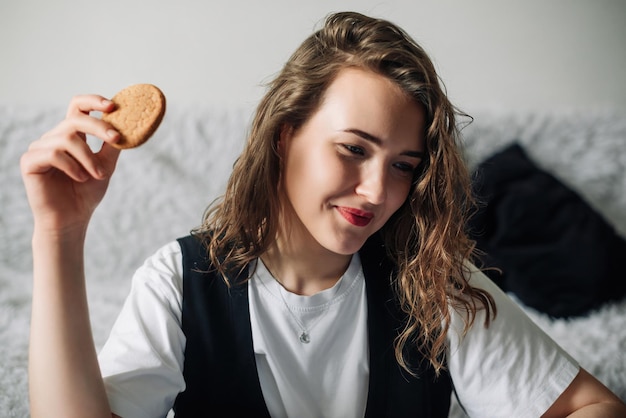 Mujer joven feliz multitarea con televisión y bocadillos relajante tecnología de entretenimiento en el hogar y