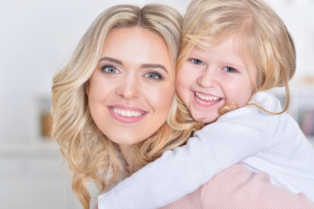 Mujer joven feliz con niña abrazando