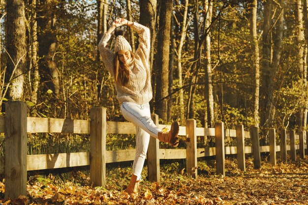 Mujer joven y feliz en el parque en un soleado día de otoño