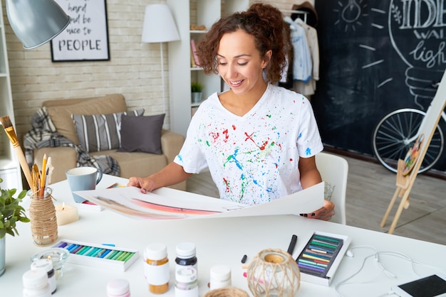 Mujer joven feliz pintando en casa