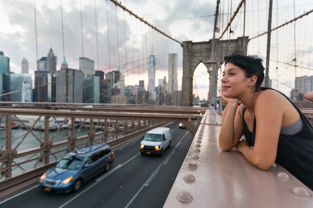 Mujer joven feliz en el puente de brooklyn