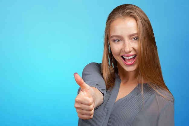 Mujer joven feliz con el pulgar hacia arriba