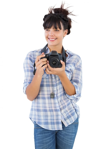 Mujer joven feliz que sostiene la cámara para tomar la imagen