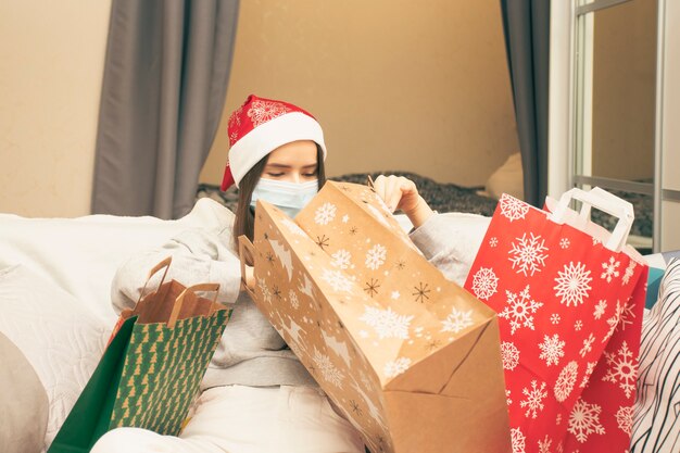 Mujer joven feliz con regalos de Navidad en casa