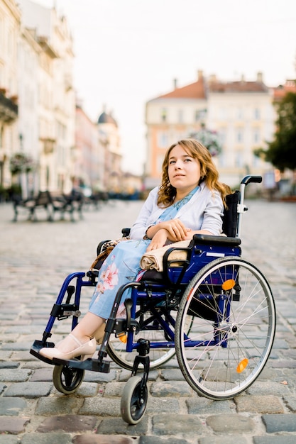 Mujer joven feliz en silla de ruedas al aire libre