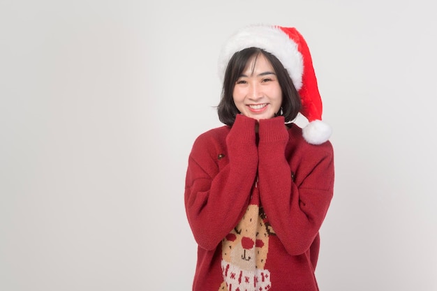 Mujer joven feliz con sombrero de Santa Claus con suéter rojo sobre fondo blanco