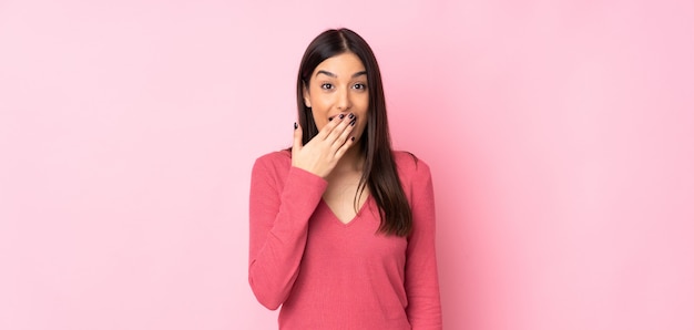 Mujer joven feliz y sonriente cubriendo la boca con la mano