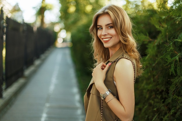 Mujer joven feliz con una sonrisa caminando en el parque