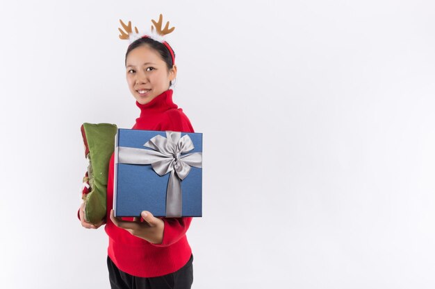 Una mujer joven y feliz sosteniendo una caja de regalo de navidad sobre fondo blanco