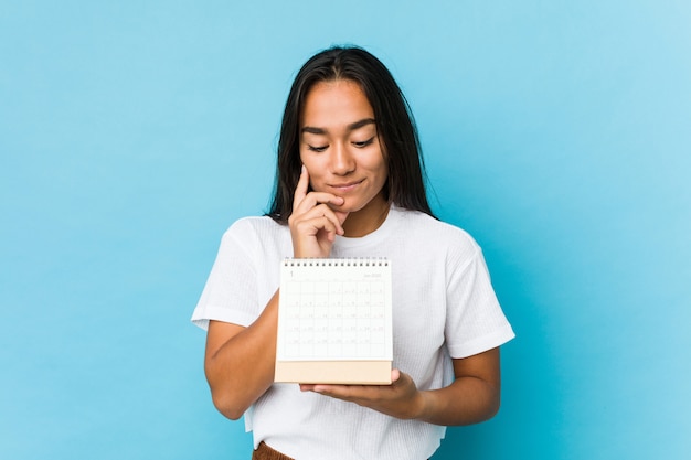 Mujer joven feliz sosteniendo un calendario