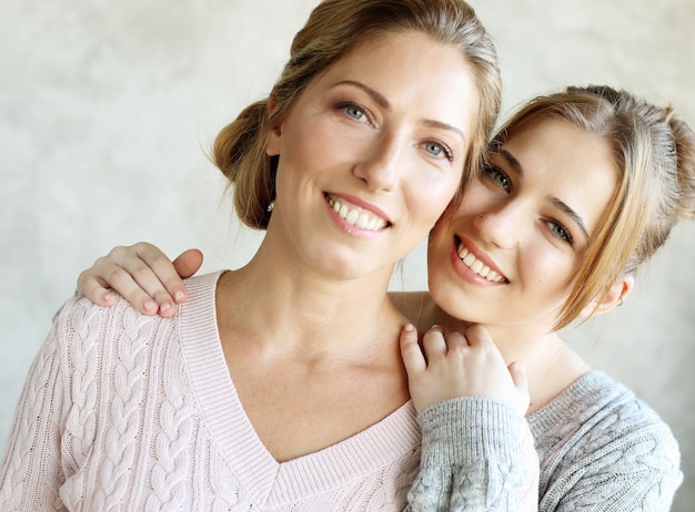 Mujer joven feliz y su madre en casa familia feliz