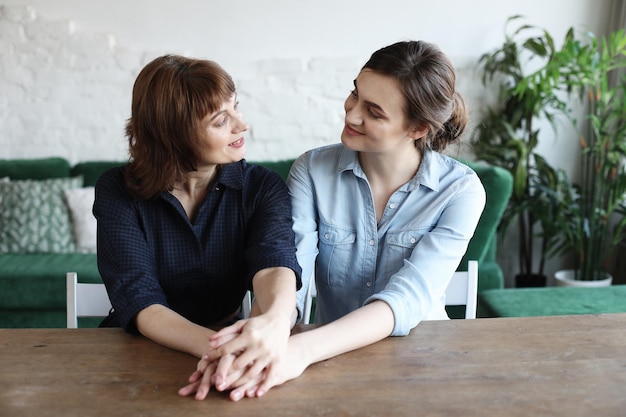 Mujer joven feliz y su madre en casa