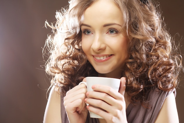 Mujer joven feliz tomando café