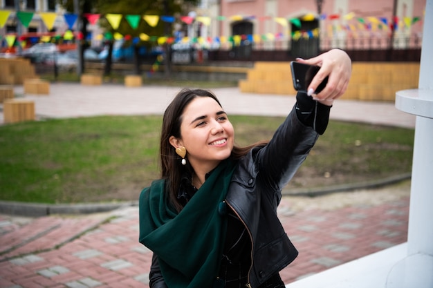 Mujer joven feliz tomando selfie. Mujer tomando foto selfie con un smarphone en la ciudad.