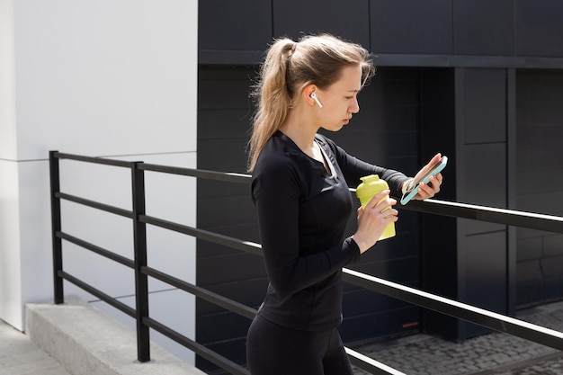 mujer joven con una figura atlética con un teléfono móvil