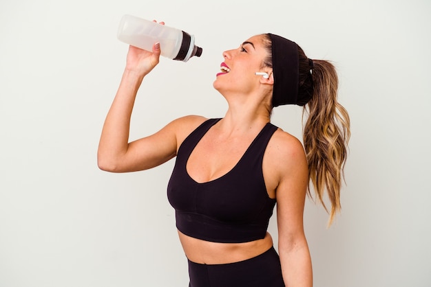 Mujer joven fitness deportivo bebiendo agua de botella aislado sobre fondo blanco.