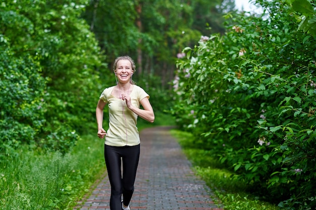 Mujer joven fitness en pista forestal.