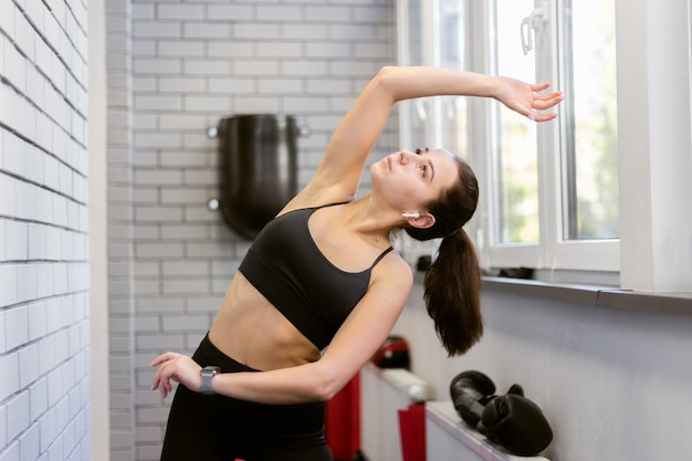 Mujer joven fitness practicando estiramientos en el interior