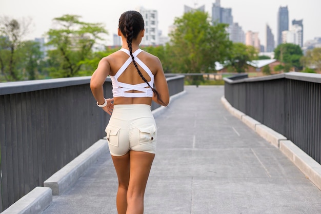 Mujer joven fitness en ropa deportiva para correr en el parque de