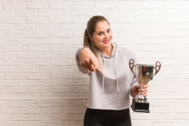 Mujer joven fitness ruso sosteniendo un trofeo