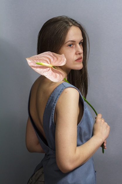 Mujer joven con una flor de anthurium