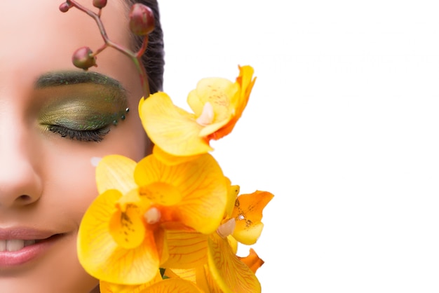 Mujer joven con la flor de la orquídea aislada en blanco