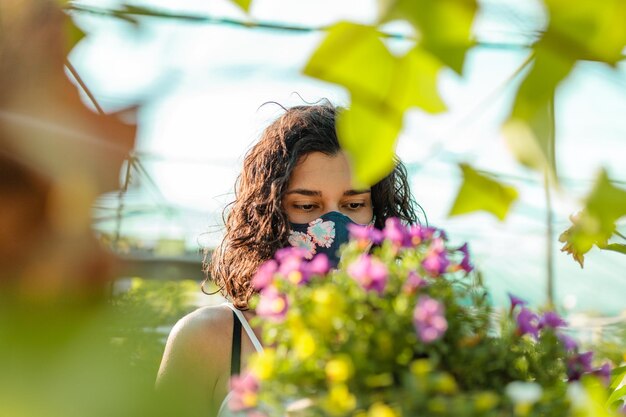 Foto mujer joven con flor rosa a la luz del sol