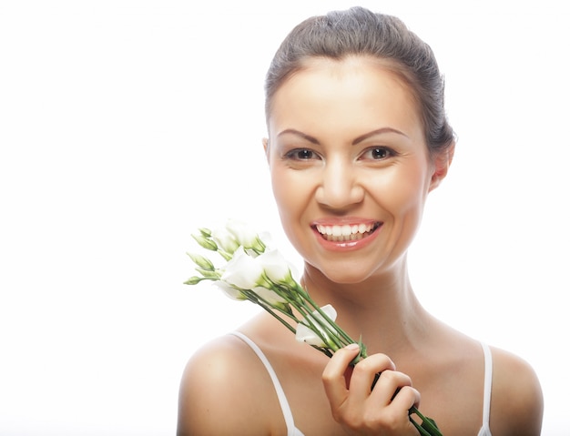 Mujer joven con flores blancas aisladas en blanco