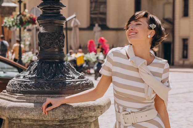 Mujer joven con flores caminando en la ciudad