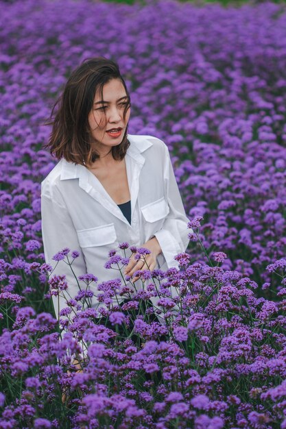 Foto mujer joven con flores en el campo