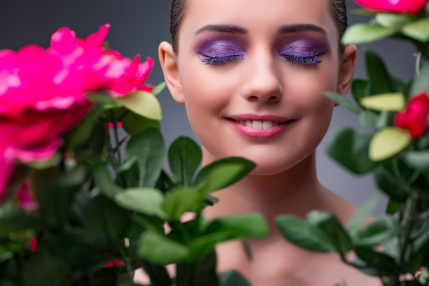 Mujer joven con flores en concepto de belleza