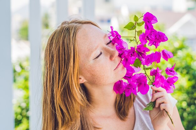 Mujer joven con flores de primavera púrpura