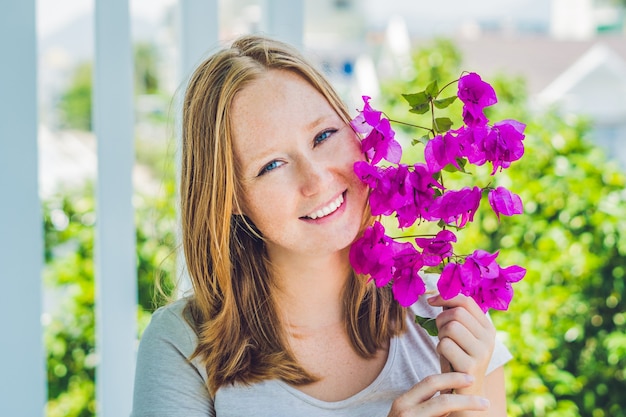 Mujer joven con flores de primavera púrpura