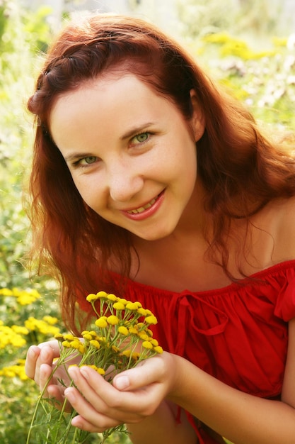 Mujer joven y flores silvestres