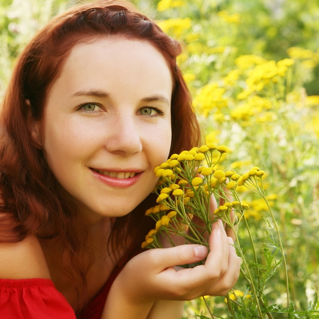 Mujer joven y flores silvestres.