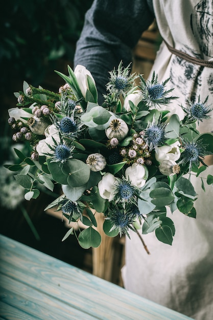 Mujer joven florista haciendo ramo de belleza