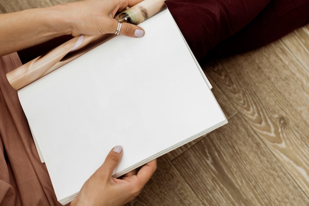 Foto mujer joven con un folleto con páginas en blanco