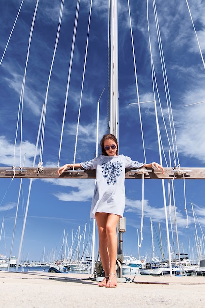 Mujer joven en el fondo del cielo azul en el puerto.