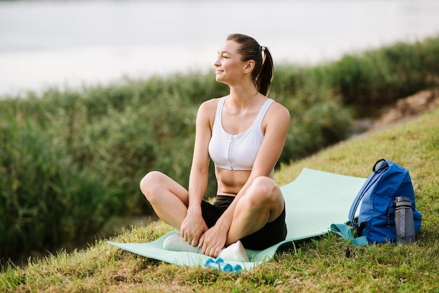 Mujer joven en forma delgada haciendo ejercicio deportivo al aire libre en el parque en el día soleado