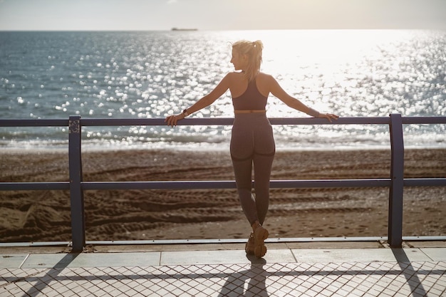 Mujer joven en forma descansando en la hermosa costa