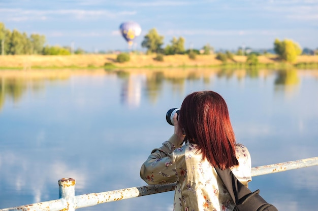 Mujer joven fotografiando un aterrizaje en globo aerostático