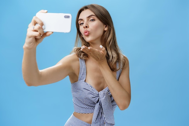 Mujer joven fotografiando con un teléfono inteligente